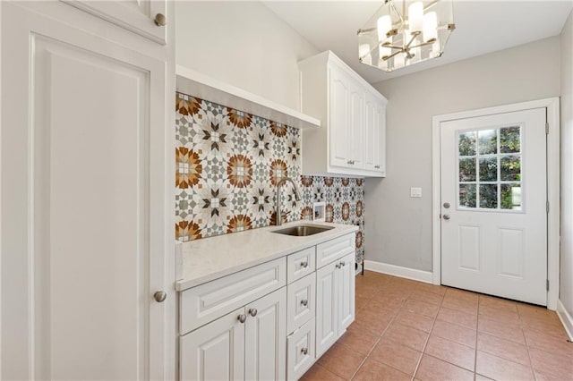 laundry area featuring a chandelier, light tile patterned floors, and sink