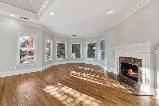 unfurnished living room featuring wood-type flooring, a fireplace, and ornamental molding