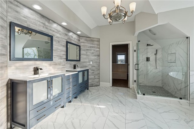 bathroom featuring an inviting chandelier, a shower with door, a healthy amount of sunlight, and tile walls