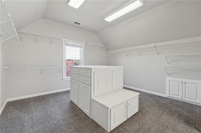 spacious closet featuring dark carpet and vaulted ceiling