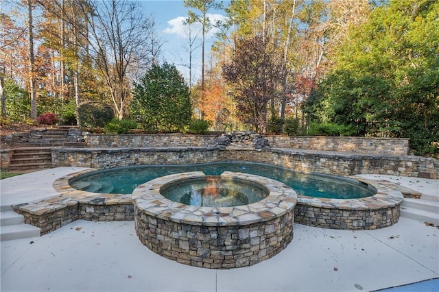 view of swimming pool featuring an in ground hot tub and a patio