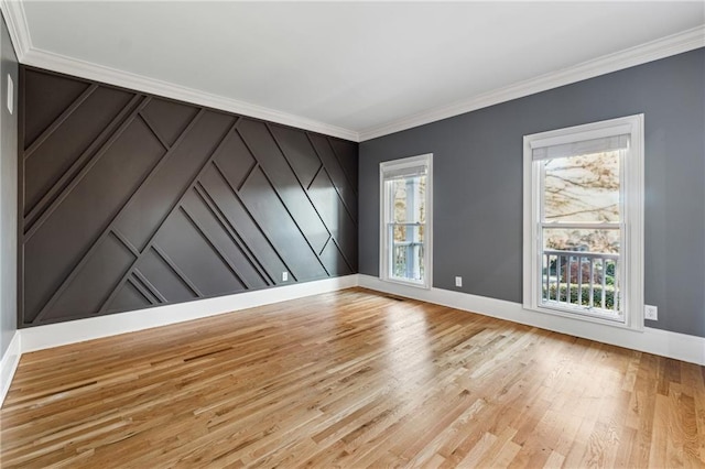 empty room with ornamental molding and light hardwood / wood-style flooring