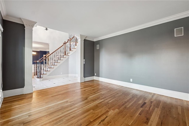 unfurnished living room featuring light hardwood / wood-style floors, ornamental molding, and ornate columns