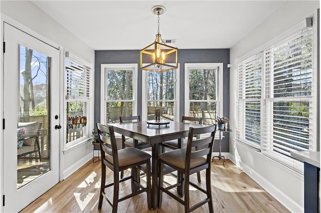 dining room with visible vents, baseboards, light wood-style floors, and a notable chandelier