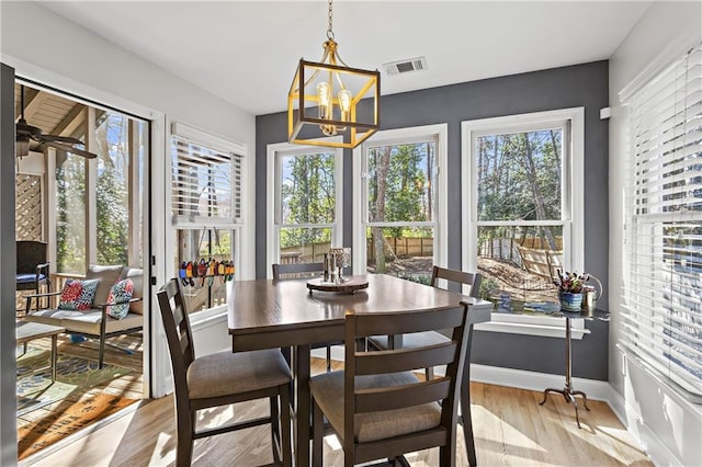 dining area with visible vents, a healthy amount of sunlight, light wood-type flooring, and baseboards