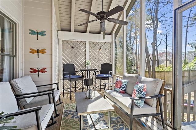 sunroom featuring lofted ceiling with beams, wood ceiling, and ceiling fan