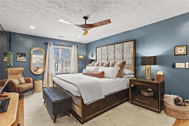 bedroom featuring visible vents, a textured ceiling, and a ceiling fan