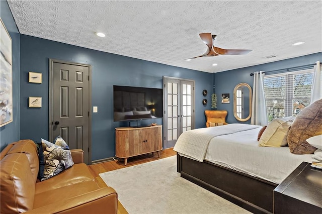 bedroom with visible vents, multiple windows, french doors, and wood finished floors