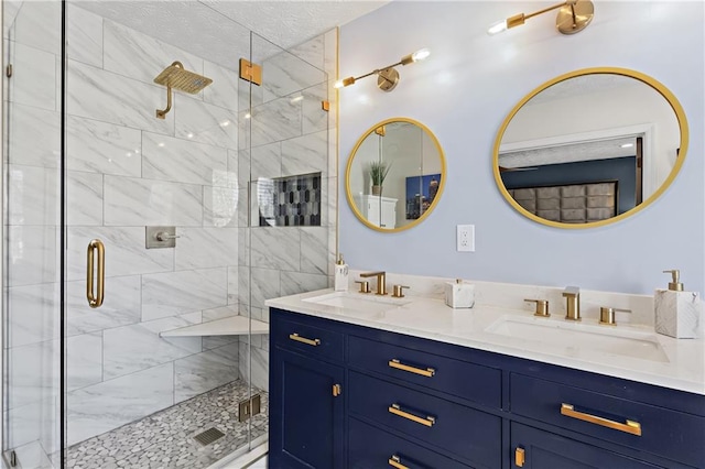 bathroom with a shower stall, double vanity, and a sink