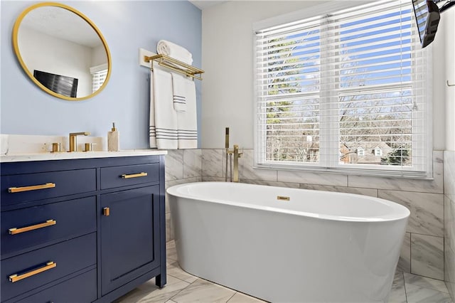 bathroom featuring plenty of natural light, marble finish floor, wainscoting, and vanity