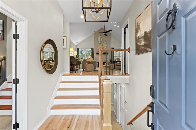 foyer featuring wood finished floors, recessed lighting, baseboards, stairs, and vaulted ceiling