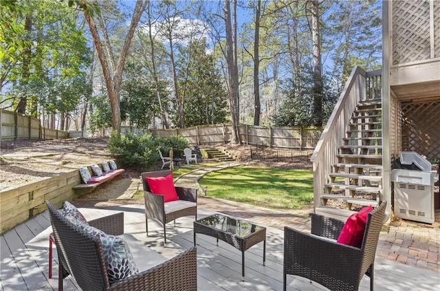 view of patio / terrace featuring a fenced backyard, a grill, a wooden deck, an outdoor hangout area, and stairs