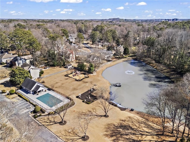 birds eye view of property with a water view and a wooded view