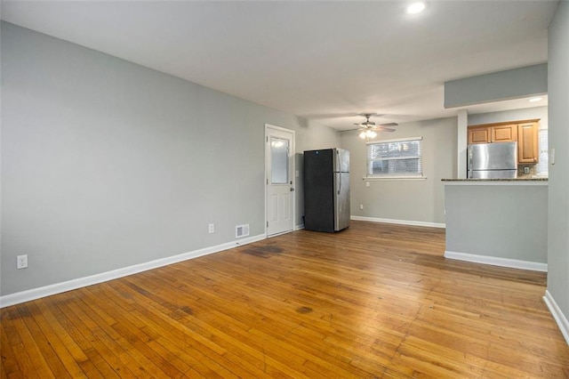 unfurnished living room with ceiling fan and light hardwood / wood-style flooring