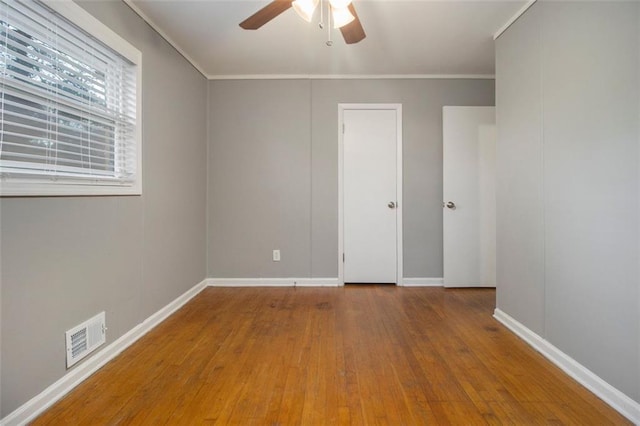 unfurnished bedroom featuring ceiling fan, wood-type flooring, and ornamental molding