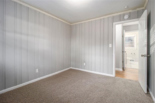 carpeted spare room featuring ornamental molding