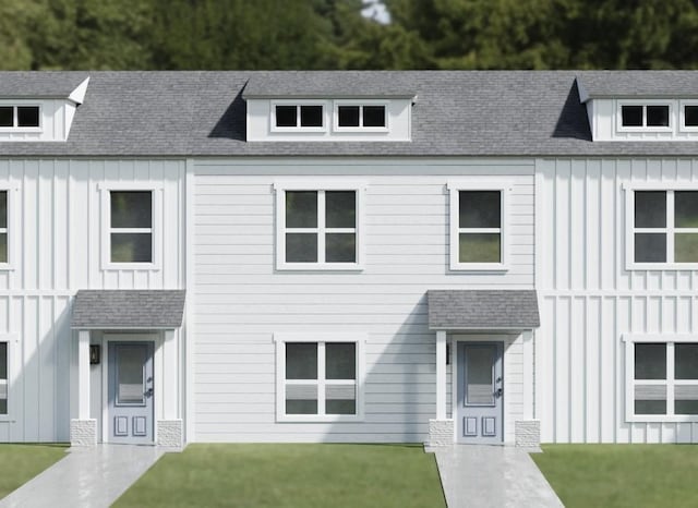 modern inspired farmhouse with a shingled roof, a front lawn, and board and batten siding