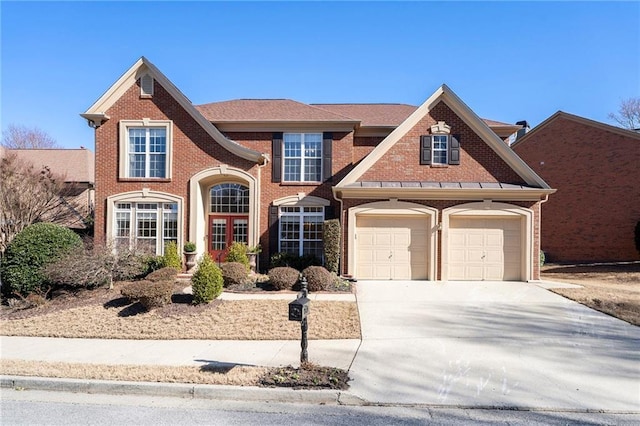 view of front of property featuring a garage, concrete driveway, and brick siding