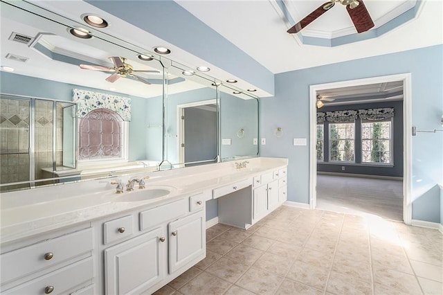 bathroom featuring ceiling fan, a tray ceiling, ornamental molding, and tile patterned floors