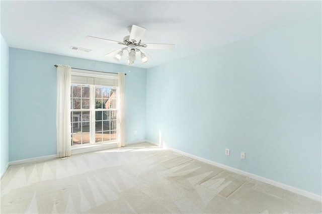 spare room with ceiling fan, carpet, visible vents, and baseboards