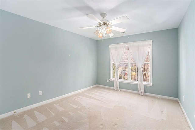 carpeted empty room featuring ceiling fan and baseboards