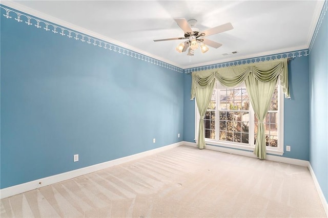 carpeted empty room with ornamental molding, a ceiling fan, visible vents, and baseboards