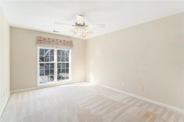 spare room with a ceiling fan, baseboards, visible vents, and carpet flooring