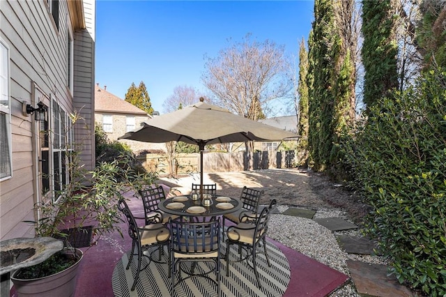 view of patio featuring outdoor dining space and fence