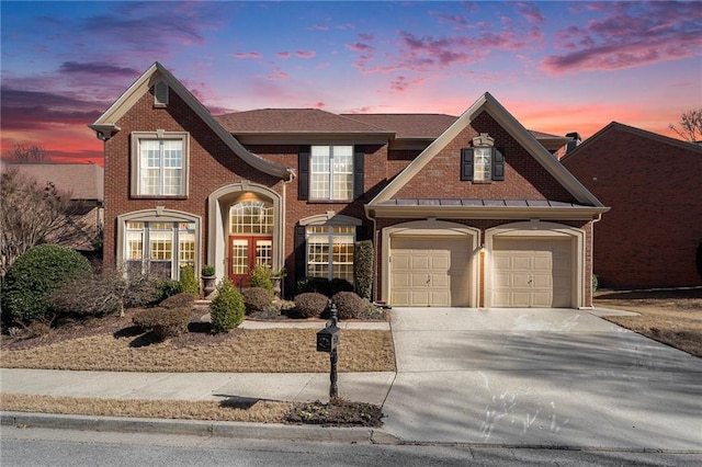 view of front of property with driveway, a garage, and brick siding