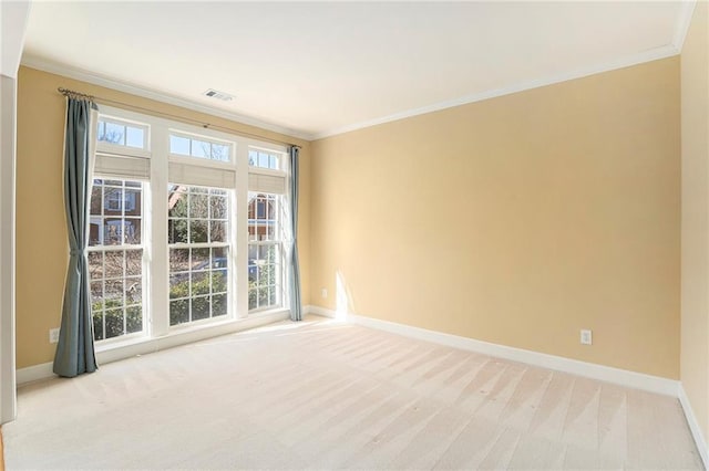 unfurnished room with ornamental molding, carpet, visible vents, and baseboards