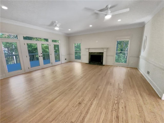 unfurnished living room with a fireplace, ornamental molding, light wood-type flooring, and ceiling fan