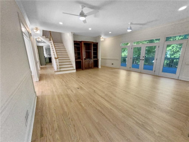 unfurnished living room featuring light hardwood / wood-style flooring, french doors, and ceiling fan