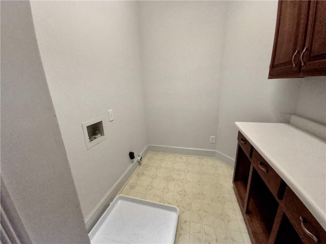 clothes washing area featuring hookup for a washing machine and cabinets