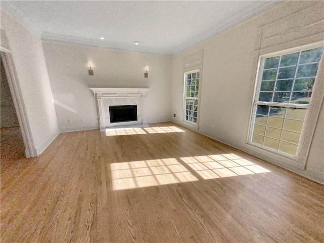 unfurnished living room featuring ornamental molding, a textured ceiling, and light hardwood / wood-style floors