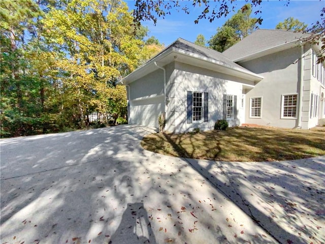 view of property exterior with a yard and a garage