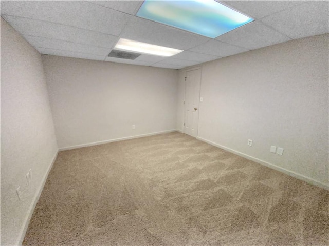 carpeted empty room featuring a paneled ceiling