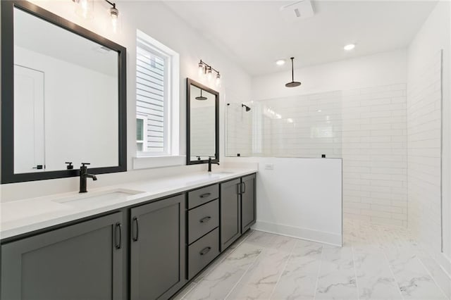 bathroom with vanity, a tile shower, and plenty of natural light