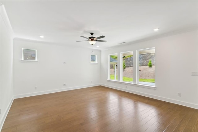 spare room with crown molding, dark hardwood / wood-style floors, and ceiling fan