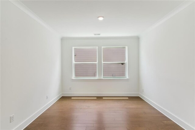 unfurnished room featuring ornamental molding and dark hardwood / wood-style flooring