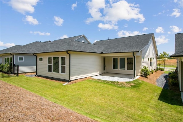 rear view of property featuring a yard and a patio area