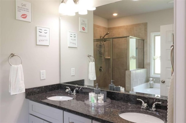 bathroom with vanity and shower with separate bathtub