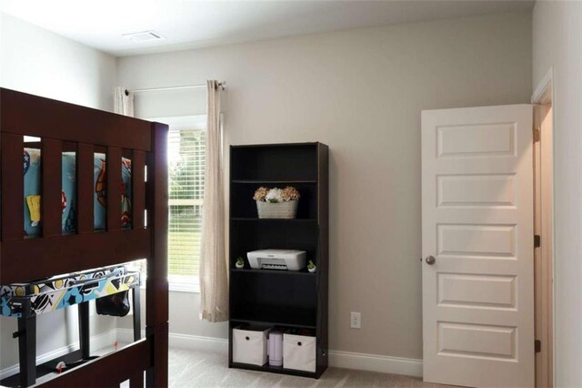 bedroom featuring light colored carpet and multiple windows