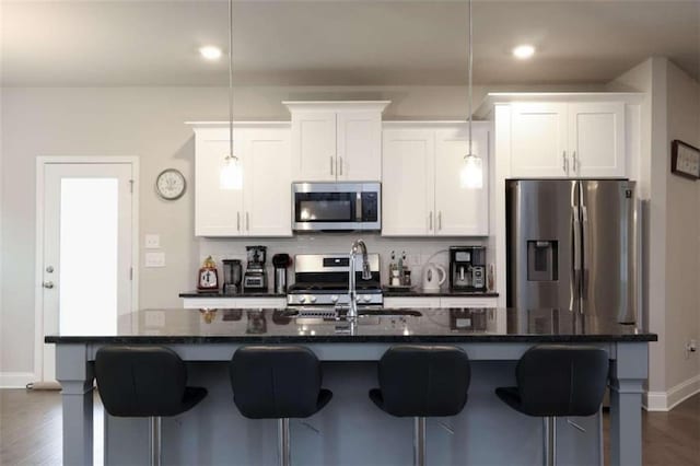 kitchen featuring sink, white cabinetry, stainless steel appliances, and an island with sink