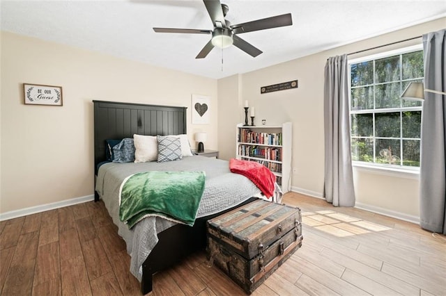 bedroom featuring wood finished floors, baseboards, and ceiling fan