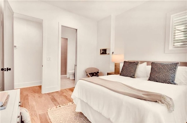 bedroom featuring light hardwood / wood-style flooring and ensuite bathroom