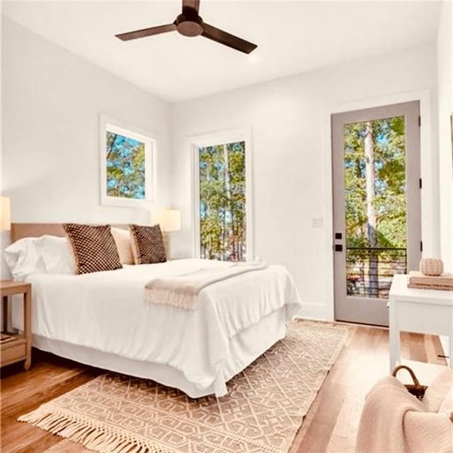 bedroom with ceiling fan, access to outside, and wood-type flooring