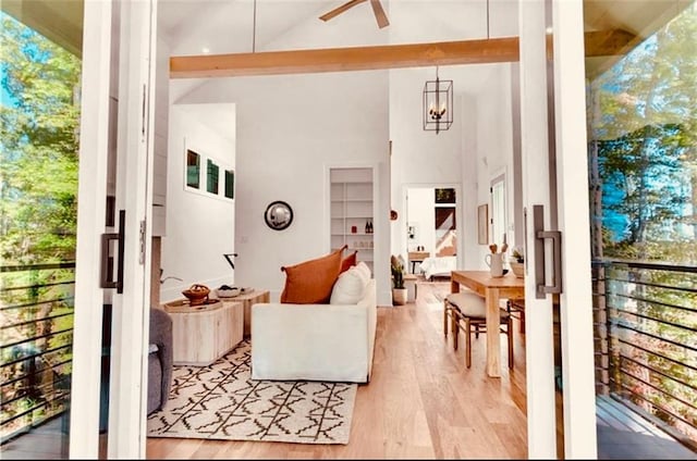 interior space featuring ceiling fan, light wood-type flooring, and high vaulted ceiling