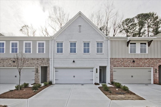 view of property featuring brick siding, driveway, and a garage