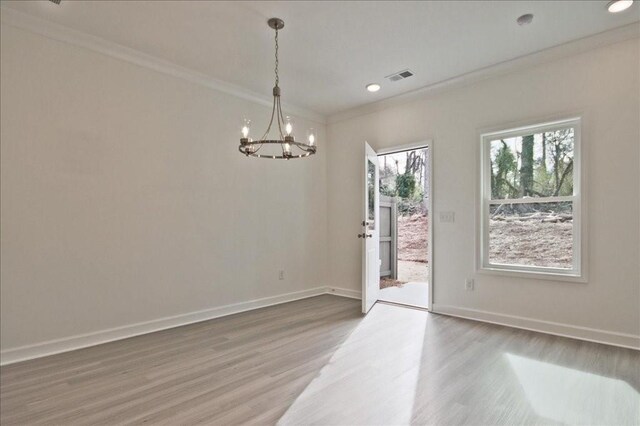 unfurnished room featuring wood finished floors, baseboards, visible vents, and ornamental molding