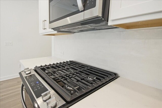 interior details with white cabinetry, light countertops, baseboards, and appliances with stainless steel finishes